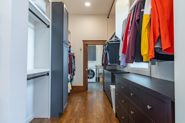 walk in closet with washer / dryer and dark hardwood / wood-style floors