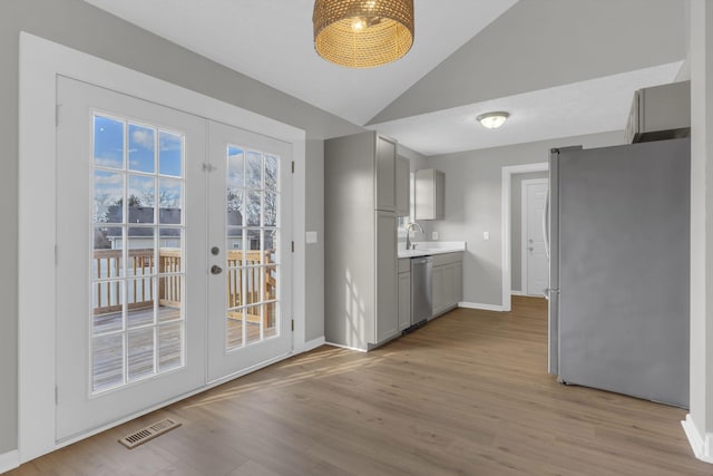 interior space with sink, light hardwood / wood-style flooring, gray cabinetry, stainless steel appliances, and french doors