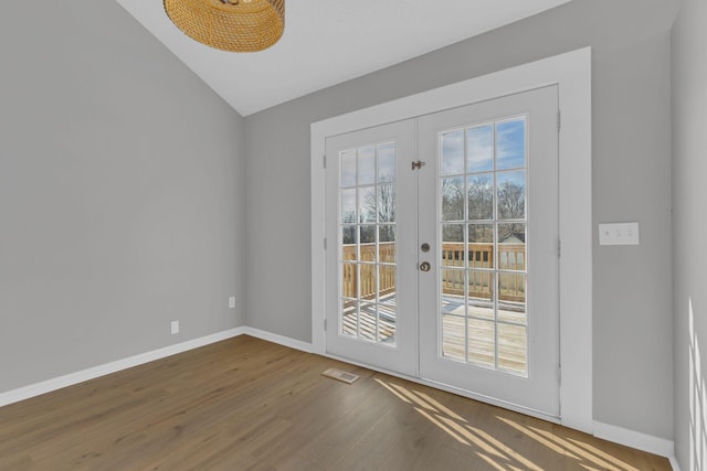 entryway featuring lofted ceiling, hardwood / wood-style flooring, and french doors