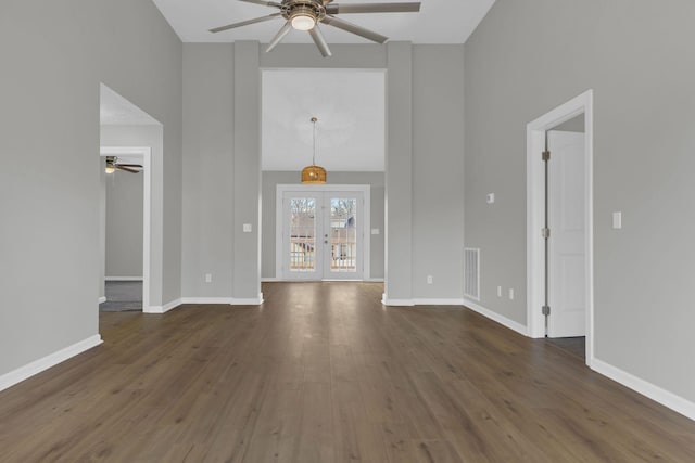 unfurnished living room with dark hardwood / wood-style floors, ceiling fan, and french doors