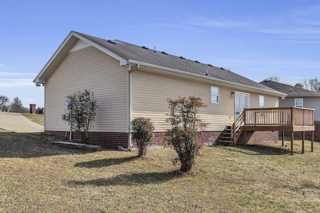 view of side of home with a yard and a deck