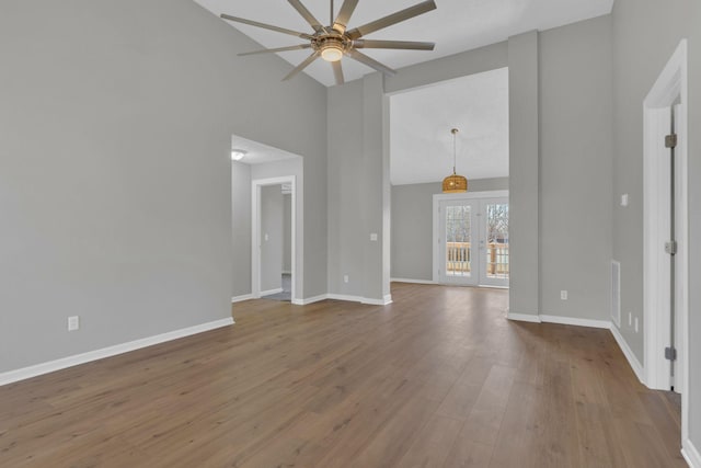 unfurnished living room featuring wood-type flooring, french doors, ceiling fan, and vaulted ceiling