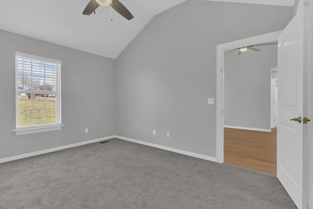 empty room featuring vaulted ceiling, carpet flooring, and ceiling fan