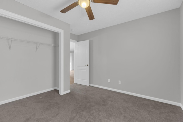 unfurnished bedroom featuring dark carpet, ceiling fan, and a closet