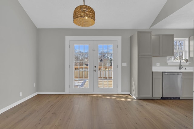 interior space with light hardwood / wood-style flooring, a wealth of natural light, french doors, and vaulted ceiling