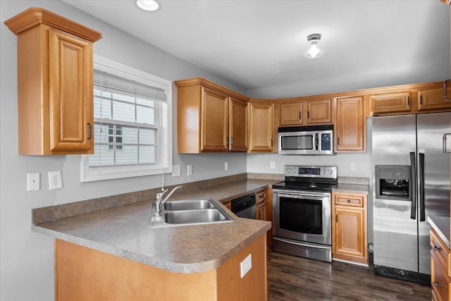 kitchen with dark hardwood / wood-style flooring, sink, kitchen peninsula, and appliances with stainless steel finishes