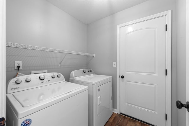 laundry room with dark hardwood / wood-style flooring and washing machine and dryer