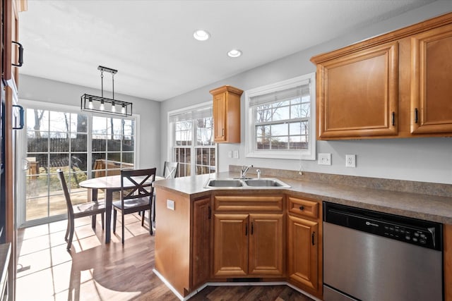 kitchen featuring sink, decorative light fixtures, light hardwood / wood-style flooring, and dishwasher