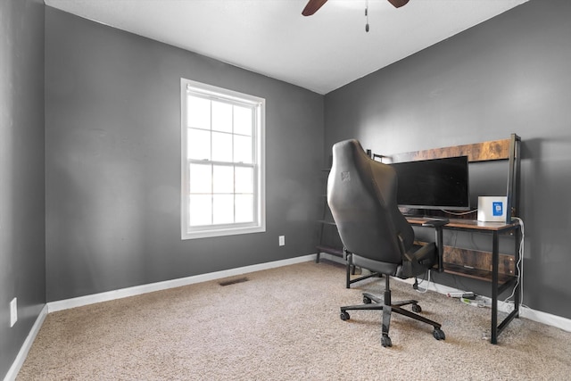 carpeted office space featuring ceiling fan