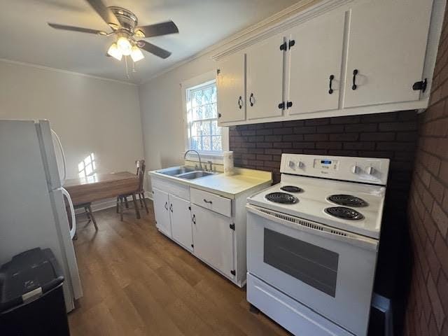 kitchen with tasteful backsplash, white cabinetry, sink, and white appliances