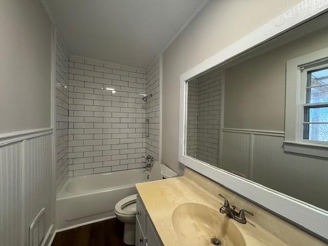 full bathroom with tiled shower / bath, vanity, and toilet