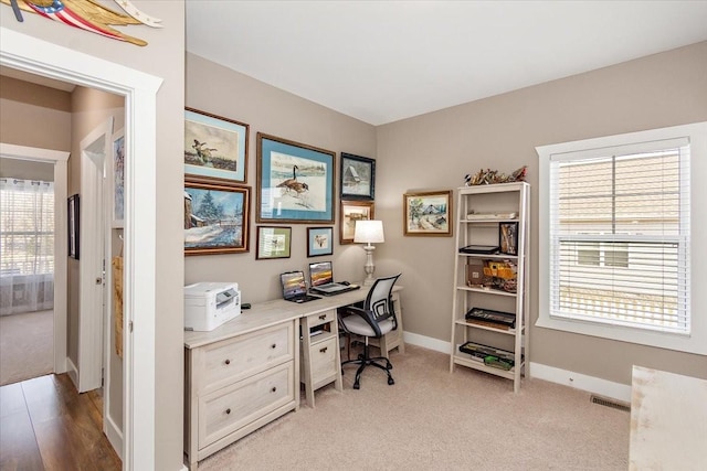 office area with plenty of natural light and light carpet