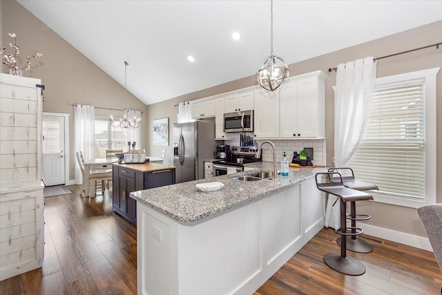 kitchen featuring a chandelier, appliances with stainless steel finishes, kitchen peninsula, and white cabinets