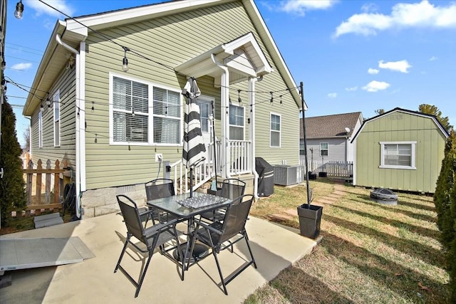 rear view of house with a storage shed, a patio area, central air condition unit, and a lawn