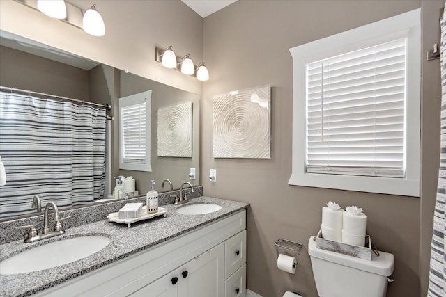 bathroom with vanity, curtained shower, and toilet