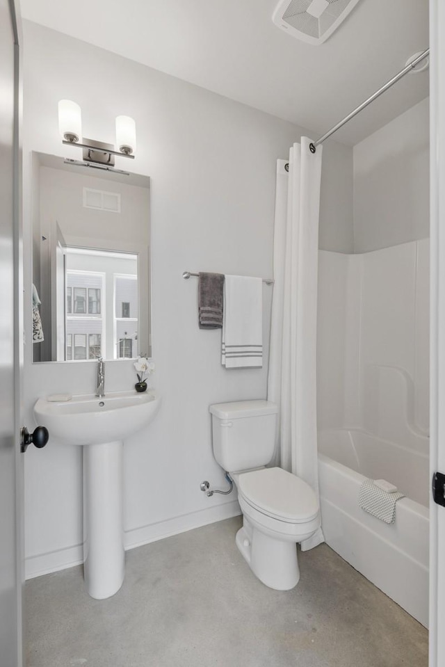 bathroom featuring shower / tub combo, concrete floors, and toilet