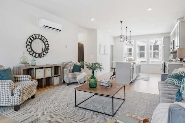 living room featuring a wall mounted air conditioner, a chandelier, and light hardwood / wood-style floors