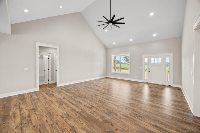 unfurnished living room with hardwood / wood-style floors, high vaulted ceiling, and ceiling fan