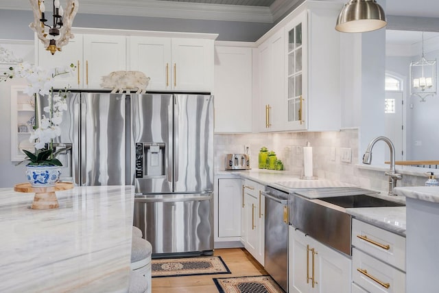 kitchen with white cabinetry, appliances with stainless steel finishes, light stone counters, and pendant lighting