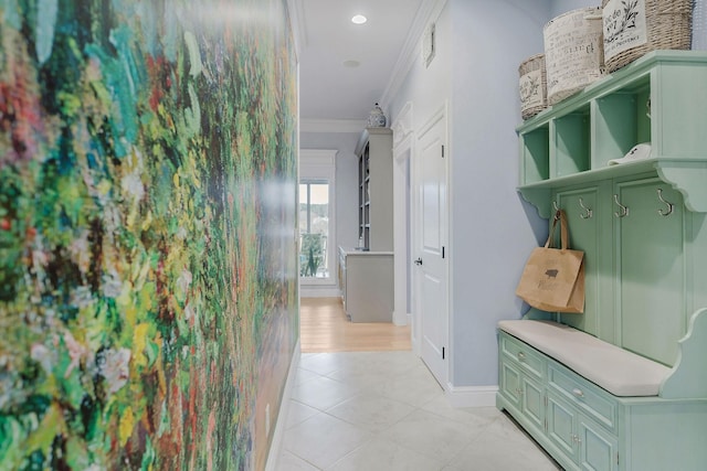 mudroom with ornamental molding and light tile patterned floors