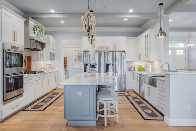 kitchen featuring stainless steel appliances, a kitchen island, and white cabinets