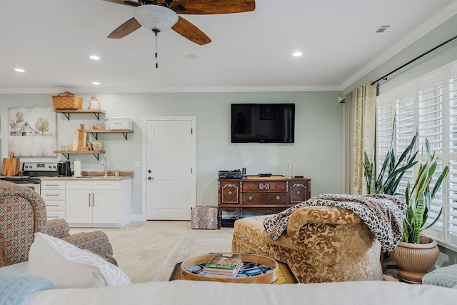 carpeted living room featuring crown molding, sink, and ceiling fan