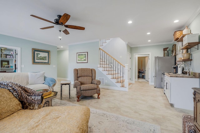 living room with sink, ornamental molding, and ceiling fan