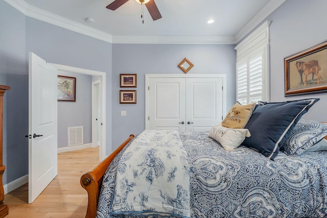 bedroom featuring crown molding, a closet, ceiling fan, and light wood-type flooring