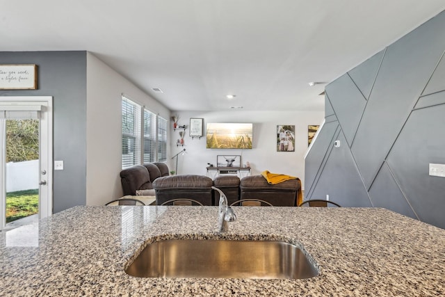 kitchen featuring stone countertops and sink