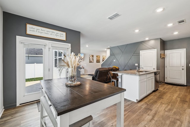 dining room featuring sink and light hardwood / wood-style flooring