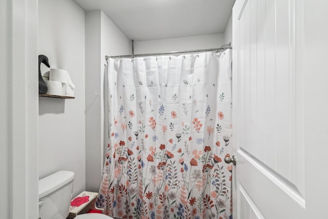 bathroom featuring curtained shower and toilet