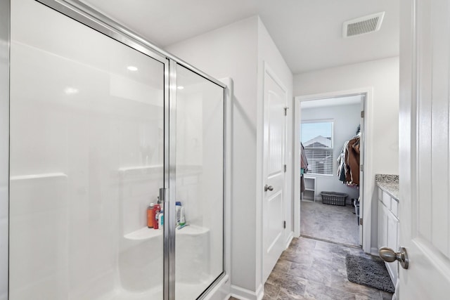 bathroom featuring vanity and a shower with door