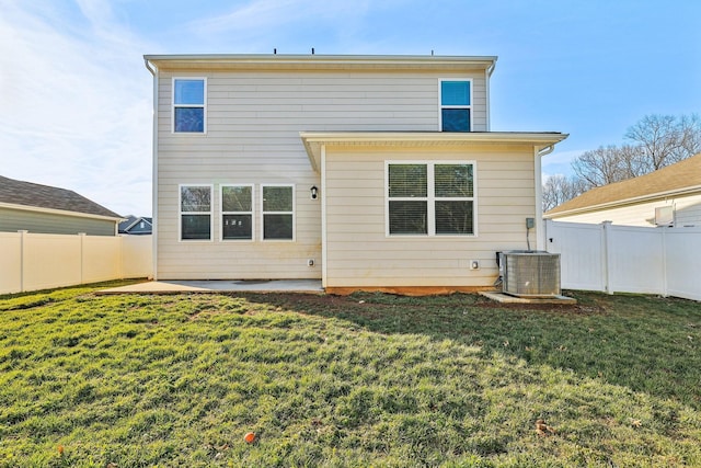 rear view of house featuring a yard, central AC unit, and a patio area