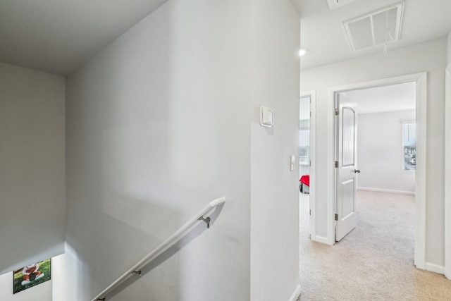 hallway featuring light colored carpet