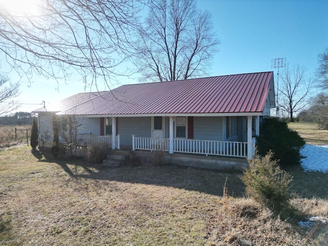 ranch-style home featuring covered porch and a front lawn