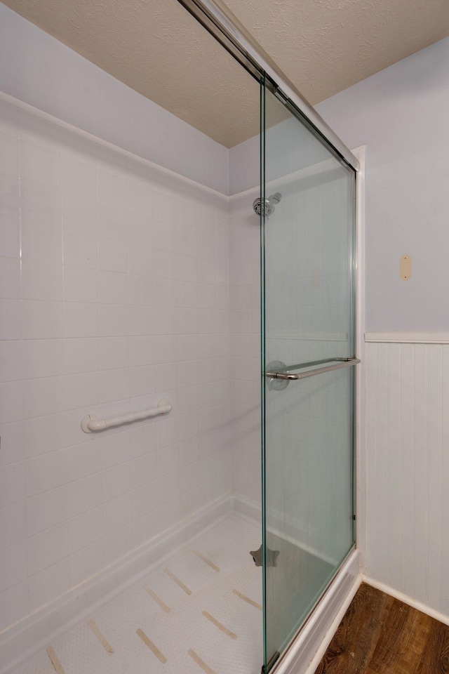 bathroom with wood-type flooring and an enclosed shower