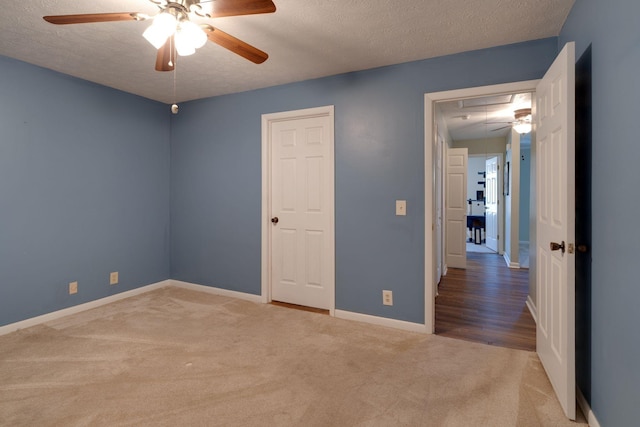 spare room with ceiling fan, carpet flooring, and a textured ceiling