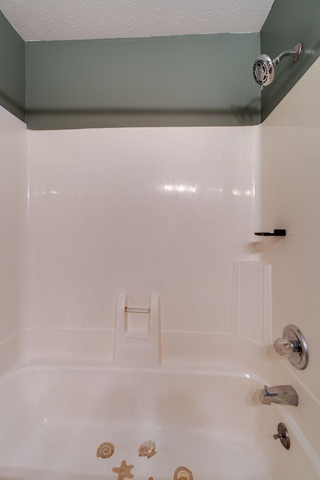 bathroom featuring bathtub / shower combination and a textured ceiling