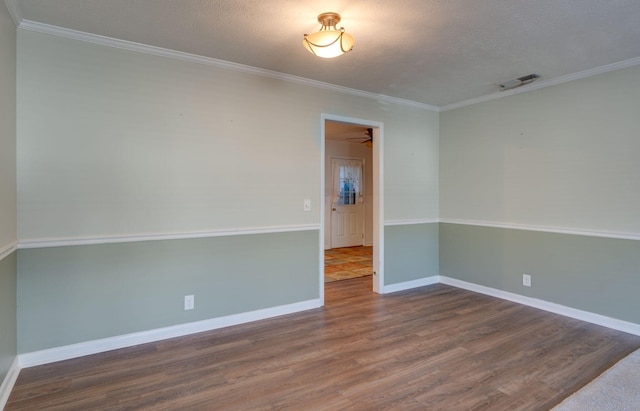 empty room with crown molding, hardwood / wood-style floors, and a textured ceiling