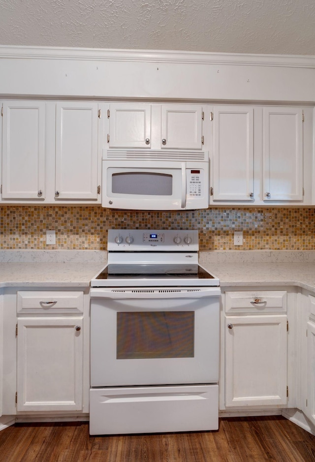 kitchen with white appliances, ornamental molding, decorative backsplash, and white cabinets