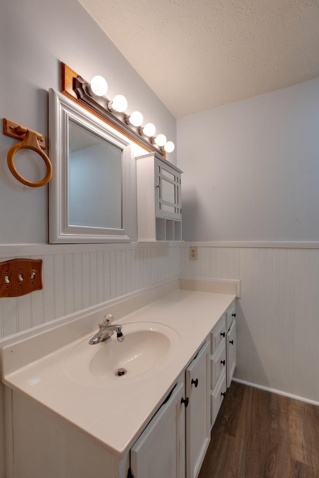 bathroom with vanity, wood-type flooring, and a textured ceiling