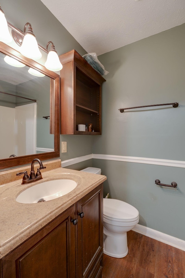 bathroom featuring hardwood / wood-style flooring, vanity, a textured ceiling, and toilet