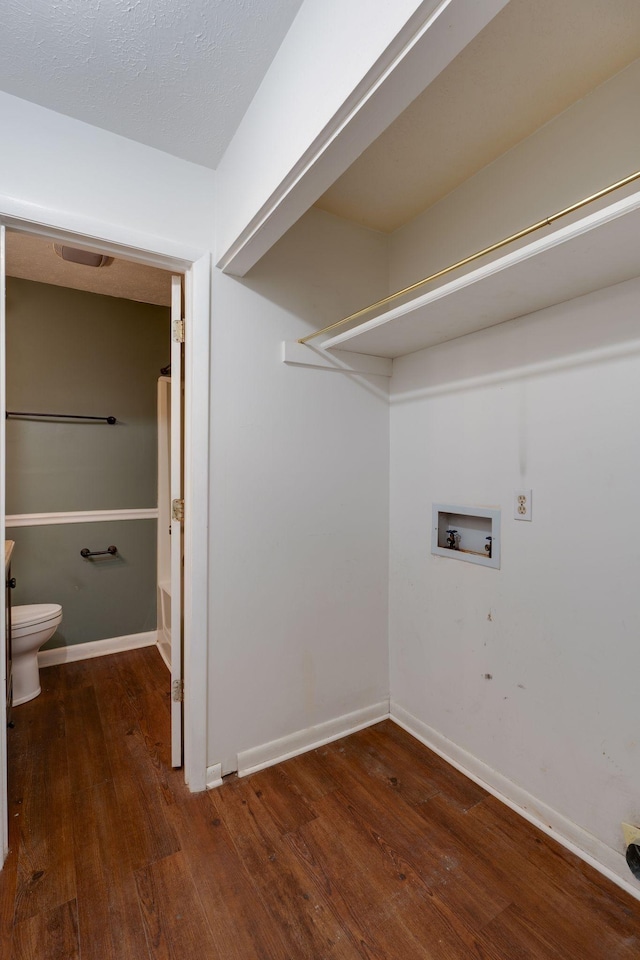 laundry room with hookup for a washing machine, dark wood-type flooring, and a textured ceiling