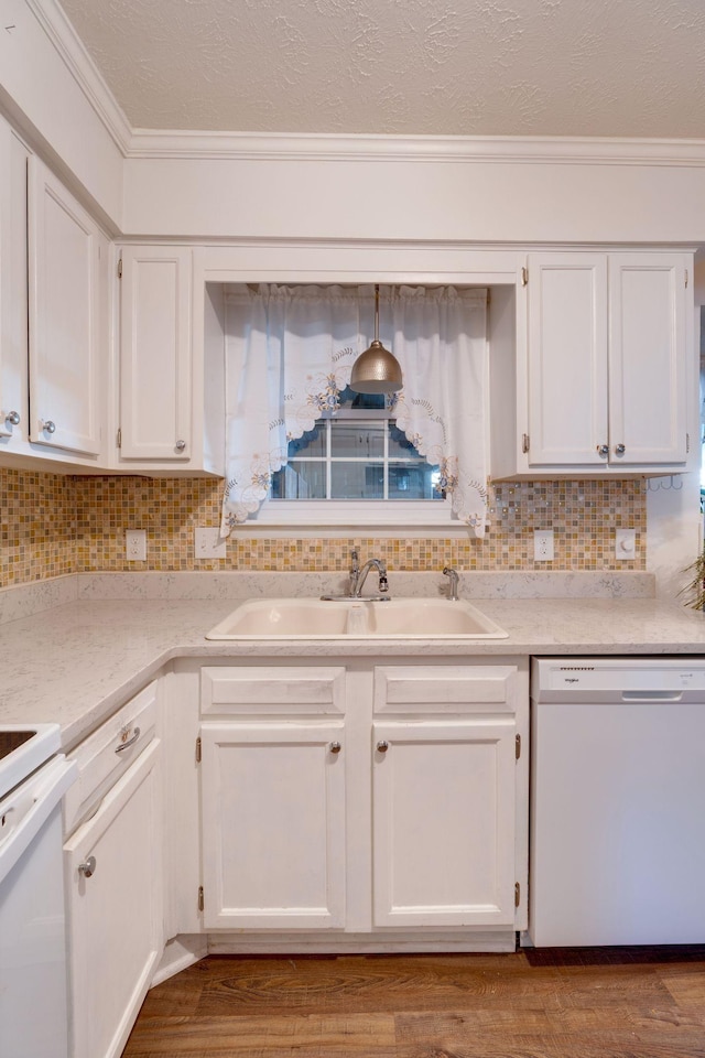 kitchen with backsplash, white dishwasher, sink, and white cabinets