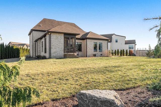 back of house with a sunroom and a lawn