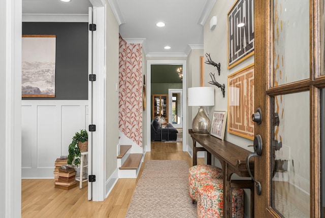 hall with crown molding and light hardwood / wood-style flooring