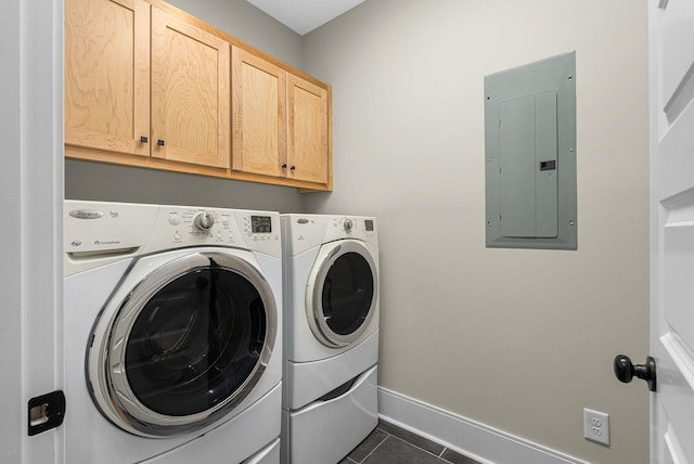 clothes washing area with washer and clothes dryer, electric panel, cabinets, and dark tile patterned floors