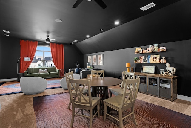 carpeted dining room with vaulted ceiling and ceiling fan