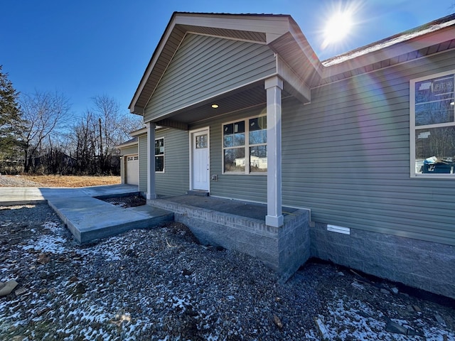 property entrance featuring a garage and covered porch