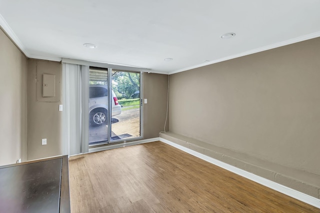 spare room featuring wood-type flooring and ornamental molding